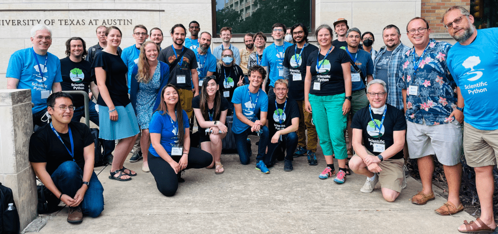Group of about 30 community members wearing Scientific Python t-shirts taken outside University of Texas at Austin during the SciPy 2022 conference.